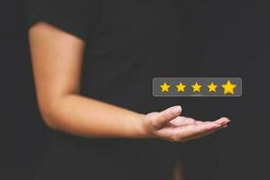 Customer pressing satisfaction with gold five star rating feedback icon and press level excellent rank for giving best score point to review the service , experience success business rate  concept. photo