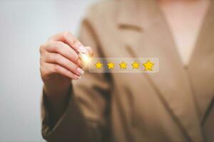 Customer pressing satisfaction with gold five star rating feedback icon and press level excellent rank for giving best score point to review the service , experience success business rate  concept. photo