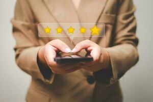 Customer pressing satisfaction with gold five star rating feedback icon and press level excellent rank for giving best score point to review the service , experience success business rate  concept. photo