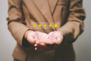 Customer pressing satisfaction with gold five star rating feedback icon and press level excellent rank for giving best score point to review the service , experience success business rate  concept. photo