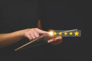 Customer pressing satisfaction with gold five star rating feedback icon and press level excellent rank for giving best score point to review the service , experience success business rate  concept. photo