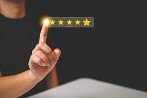 Customer pressing satisfaction with gold five star rating feedback icon and press level excellent rank for giving best score point to review the service , experience success business rate  concept. photo