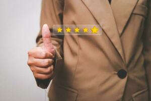 Customer pressing satisfaction with gold five star rating feedback icon and press level excellent rank for giving best score point to review the service , experience success business rate  concept. photo