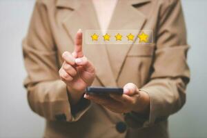 Customer pressing satisfaction with gold five star rating feedback icon and press level excellent rank for giving best score point to review the service , experience success business rate  concept. photo