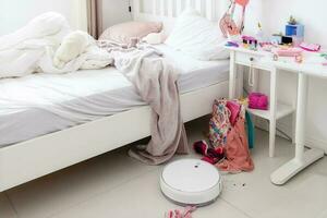 Cleaning with a robotic vacuum cleaner at home. Mess in the girl's room. copy paste space photo
