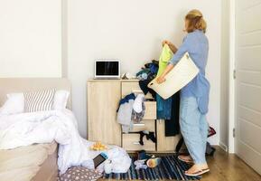 woman entered her child's room with a mess to collect dirty things and clean up photo