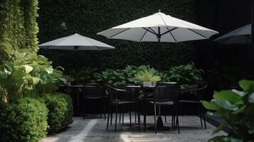 Cafe garden with modern green tropical plants, round glass coffee table with umbrella. photo