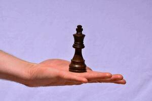 Hand holding a chess piece photo