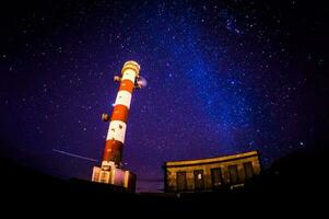 noche cielo imagen de un faro torre foto