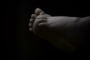 Beautiful baby girl lying down with feet up black and white photo