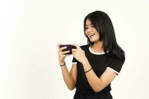 jugar juegos móviles en el teléfono inteligente de una hermosa mujer asiática aislada de fondo blanco foto