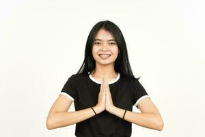 sonriente y haciendo namaste saludo de hermosa asiático mujer aislado en blanco antecedentes foto