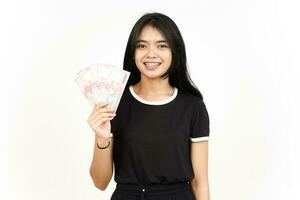sosteniendo un billete de 100000 rupias de una hermosa mujer asiática aislada de fondo blanco foto