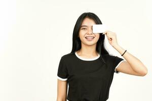 sosteniendo una tarjeta bancaria en blanco o una tarjeta de crédito de una hermosa mujer asiática aislada de fondo blanco foto