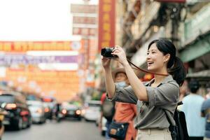 Young Asian woman backpack traveler enjoying China town street food market in Bangkok, Thailand. Traveler checking out side streets. photo