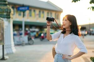 Portrait of asian woman traveler using camera at street of Bangkok, Thailand. Asia summer tourism vacation concept photo