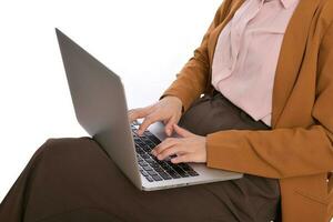 Close up of a business woman using laptop on her lap while sitting photo