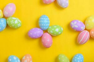 Happy easter holiday celebration concept. Group of painted colourful eggs decoration on a yellow background. Seasonal religion tradition design. Top view, flat lay, copy space. photo