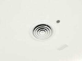 Ceiling mounted cassette type air conditioner and modern lamp light on white ceiling. duct air conditioner for home or office photo