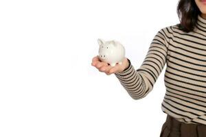 Portrait of young Asian woman casual uniform holding white piggy bank isolated on white background, Financial and bank saving money concept photo