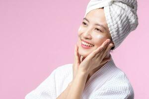 Young asian woman applying facial skincare face cream, cosmetic moisturiser on healthy natural skin make up face. Portrait glowing smile girl person model with care beauty product, spa, cosmetology. photo