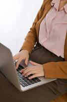 Close up of a business woman using laptop on her lap while sitting photo