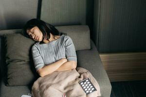 Asian woman with cold and flu sleeping on sofa bed at home. photo