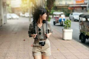 Young Asian woman backpack traveler enjoying street cultural local place and smile. Traveler checking out side streets. photo