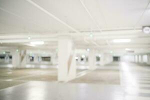 Blur image of empty car park in basement of garage shopping mall. Defocused interior background concept photo