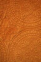 Close Up Detail of Burnt Orange Colored Quilted Material photo