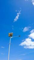 a street lamp pole that uses solar power with a clear sky photo