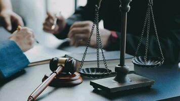 Business and lawyers discussing contract papers with brass scale on desk in office. Law, legal services, advice, justice and law concept picture with film grain effect video