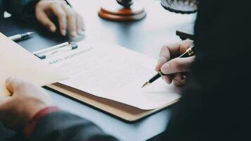 zaken en advocaten bespreken contractpapieren met koperen schaal op bureau in kantoor. wet, juridische diensten, advies, rechtvaardigheid en wet concept foto met film grain effect video