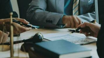 zaken en advocaten bespreken contractpapieren met koperen schaal op bureau in kantoor. wet, juridische diensten, advies, rechtvaardigheid en wet concept foto met film grain effect video