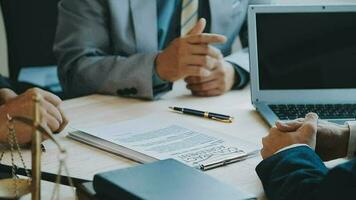 Business and lawyers discussing contract papers with brass scale on desk in office. Law, legal services, advice, justice and law concept picture with film grain effect video