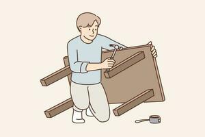 Man assembles table buying it in furniture store and repairs DIY wooden desk for kitchen. Guy is assembling furniture using screwdriver to fix legs during DIY repairs in appartment vector