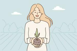 Woman demonstrates handful of soil with young plant for concept of caring for nature and celebrating earth day. Happy woman who wants to go into gardening or farming business stands on plantation vector