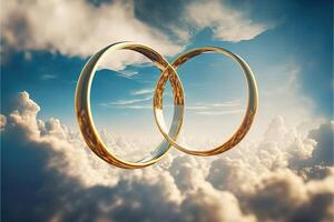 A pair of gold wedding rings floating in the sky. two wedding rings floating in the clouds with a sun in the background and a blue sky with clouds below them. . Wedding concept. photo