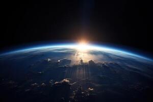 Sunrise view of the planet Earth from space with the sun setting over the horizon. photo