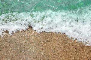 Ocean wave on sandy beach photo