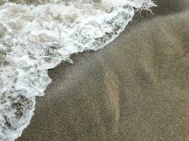 Sea wave on sandy beach photo