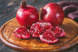 Fresh pomegranates on the wooden table photo