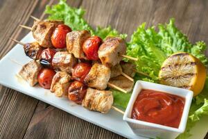 Grilled chicken skewers on the white plate photo