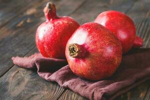 Fresh pomegranates on the wooden table photo