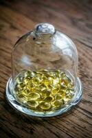 Omega 3 cápsulas debajo el vaso Hazme foto