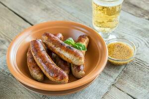 salchichas a la parrilla con un vaso de cerveza foto