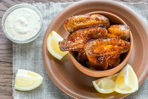 Caramelized chicken wings with glass of beer photo