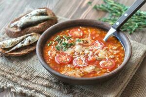 Portion of green lentil tomato soup with toasts photo