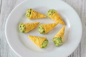 Tortilla chips cones with guacamole photo