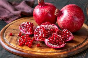 Fresh pomegranates on the wooden table photo